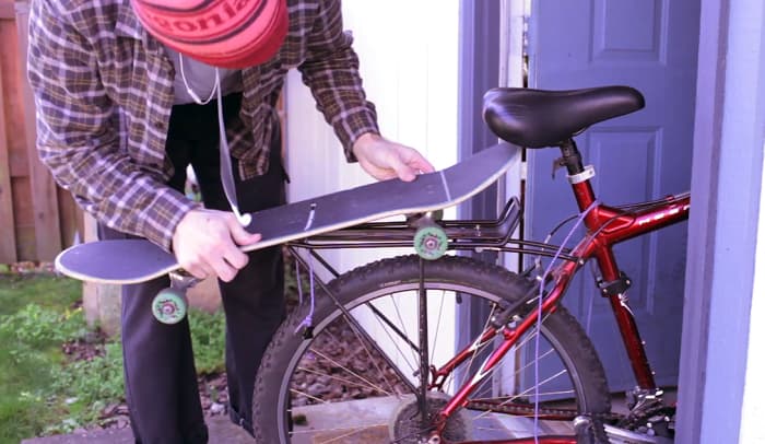 how to carry a skateboard on a bike